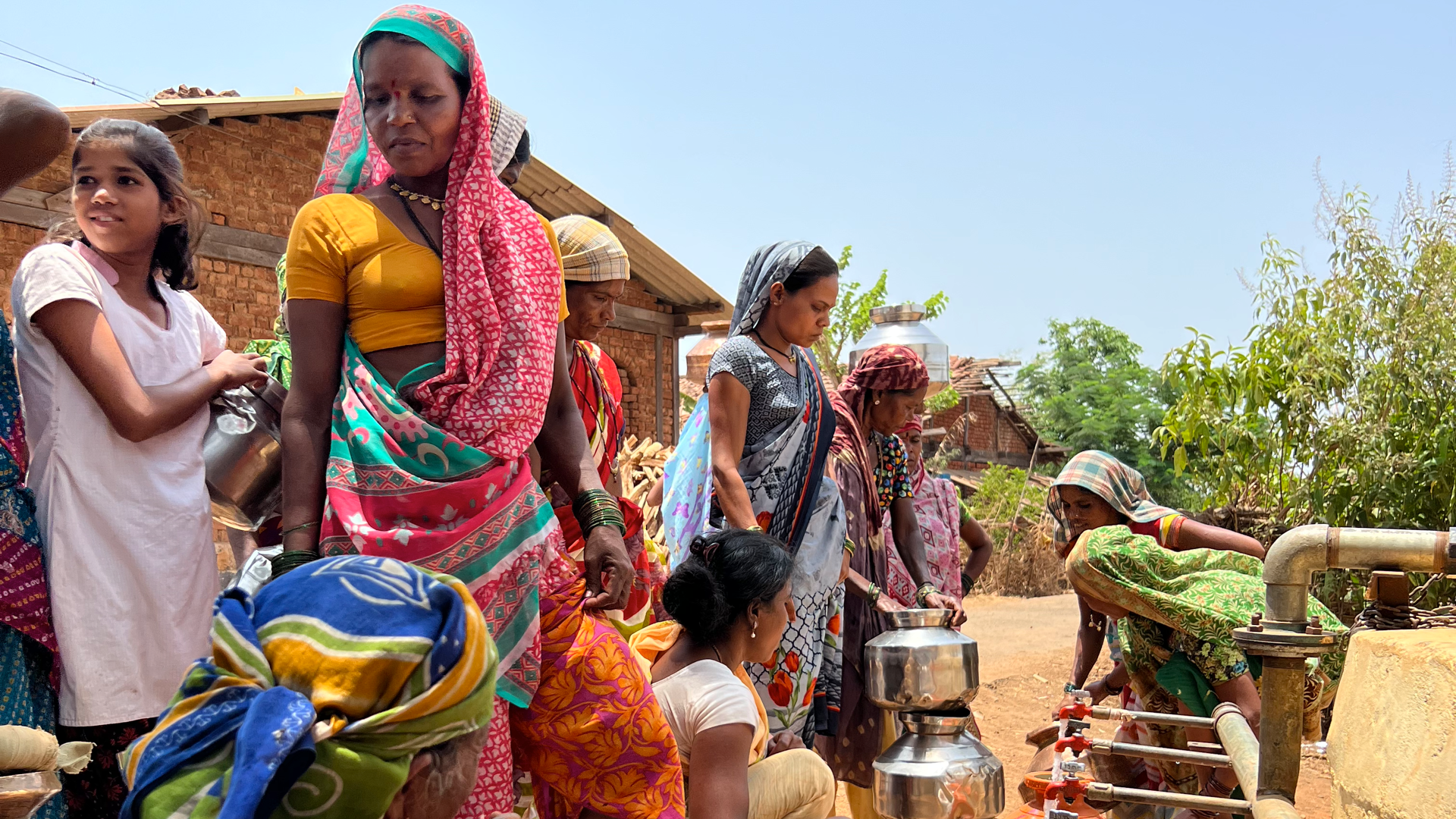 Women filling water carriers at taps
