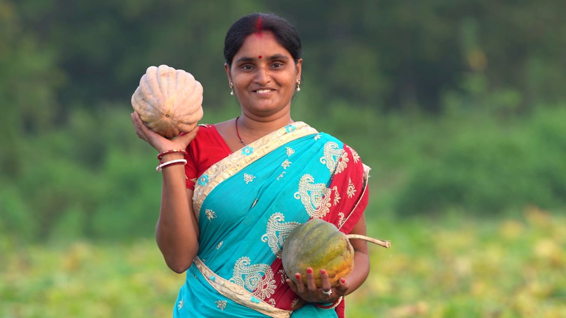 A woman holding two big fruit 