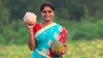 A woman holding two big fruit
