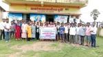 Group of people standing in front of a building with a banner in a rural area credit to Watershed Organisation Trust